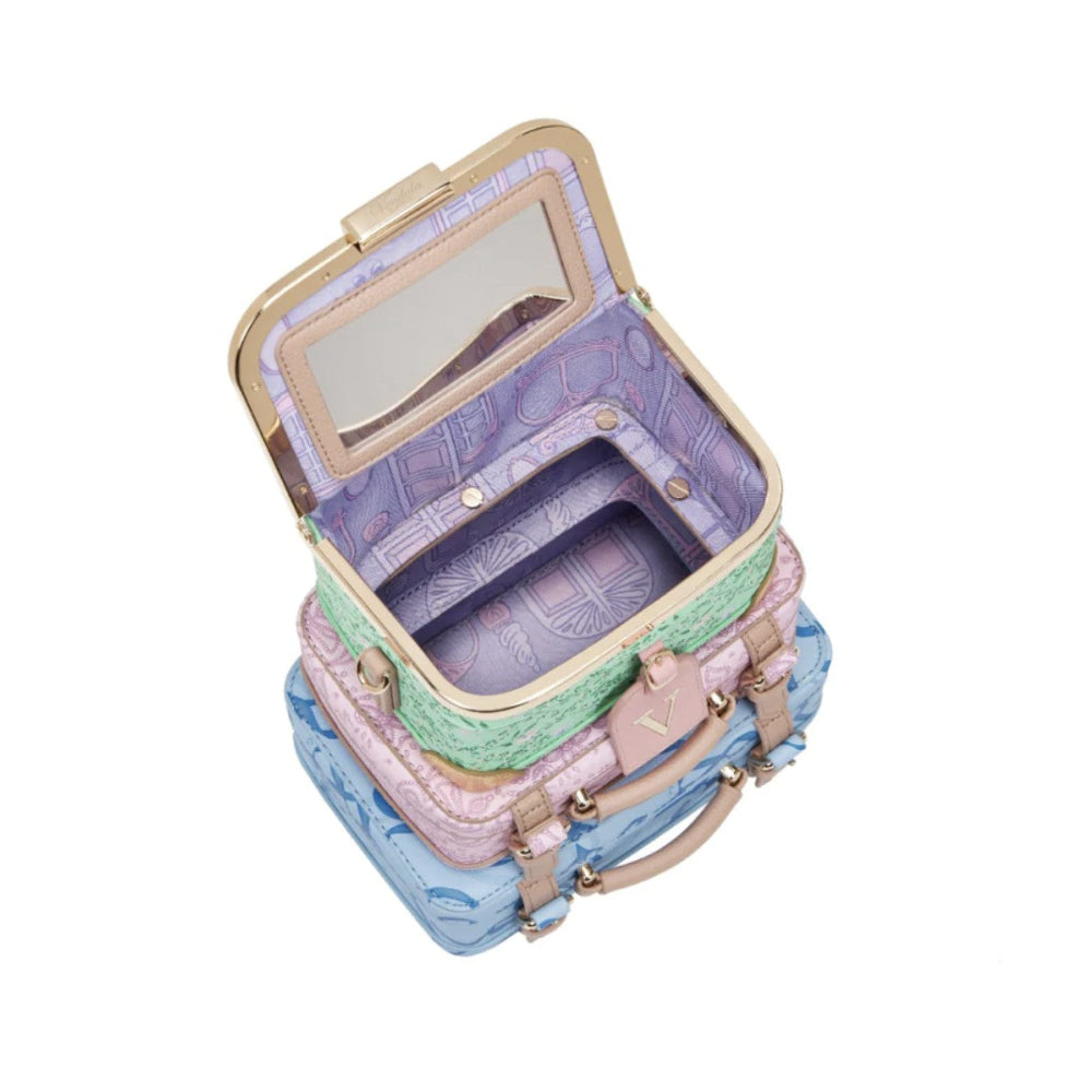 Stack of pastel-colored suitcase style bags with a mirror on a white background
