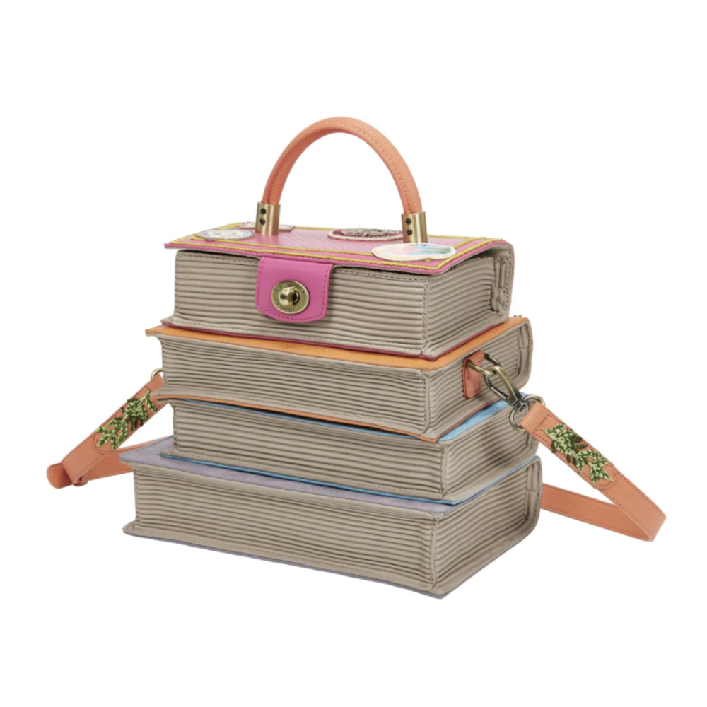 Stack of book-shaped bags with a pink strap and handle on a white background