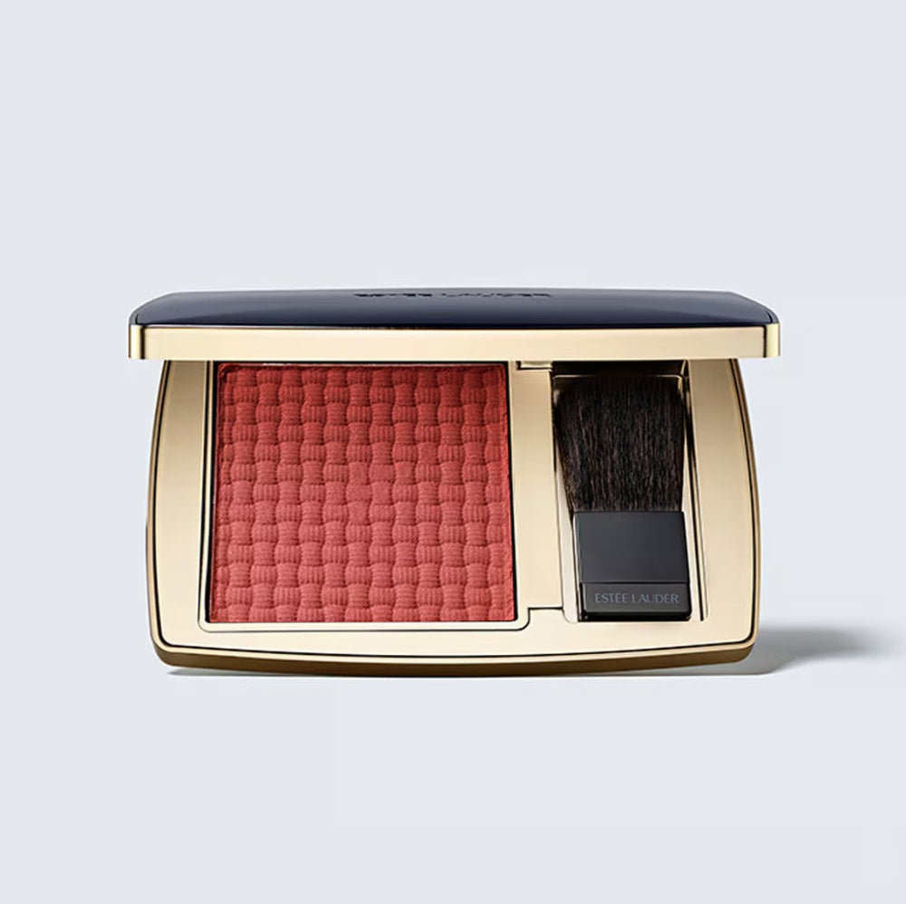 Compact blush with a brush on a light gray background