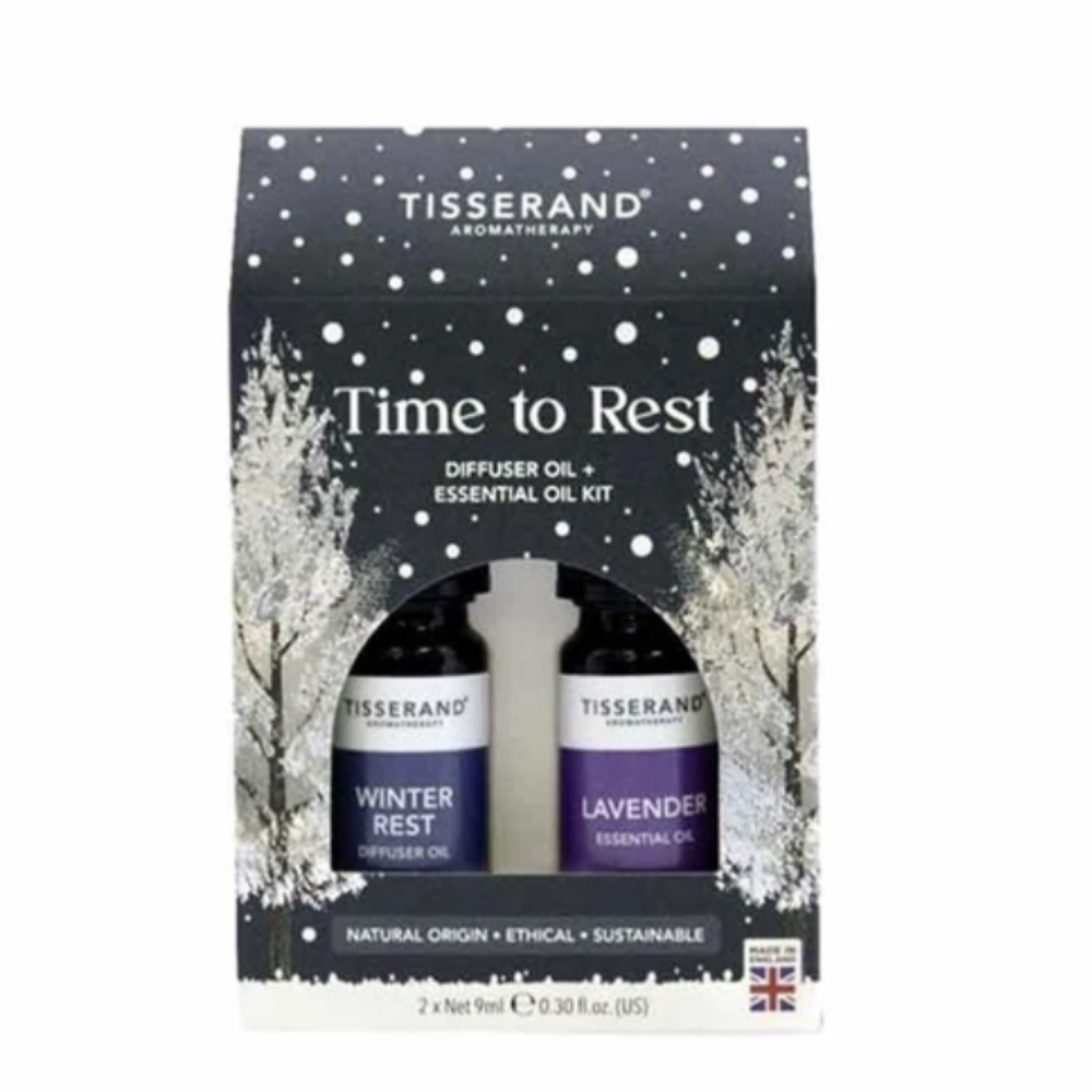 Tisserand Aromatherapy 'Time to Rest' diffuser oil and essential oil kit in a black gift box with white snowflake and tree illustrations, containing Winter Rest and Lavender bottles.