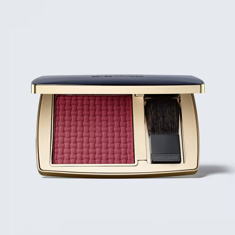 Makeup compact with pink blush and brush on a light gray background