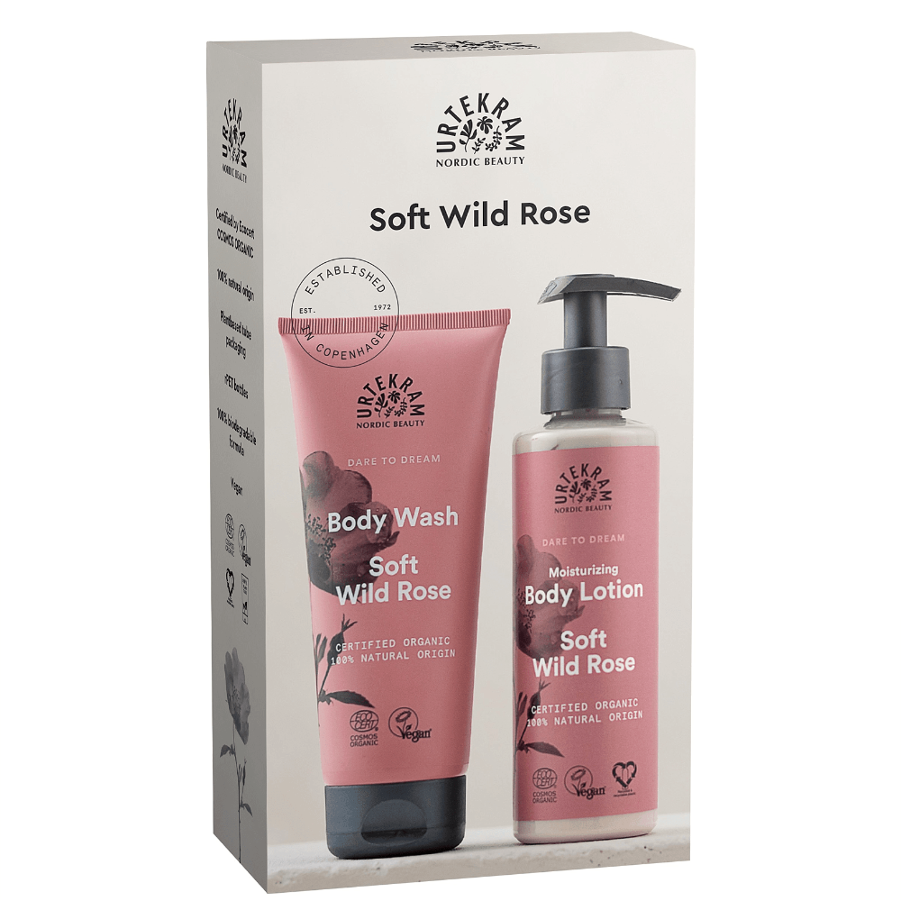 Nordic Beauty Soft Wild Rose body wash and emollient body lotion set in its original packaging box, featuring pink tubes and bottles with black pumps on a beige background.