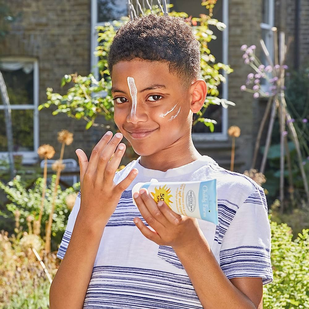 Boy with sun protection cream on his face