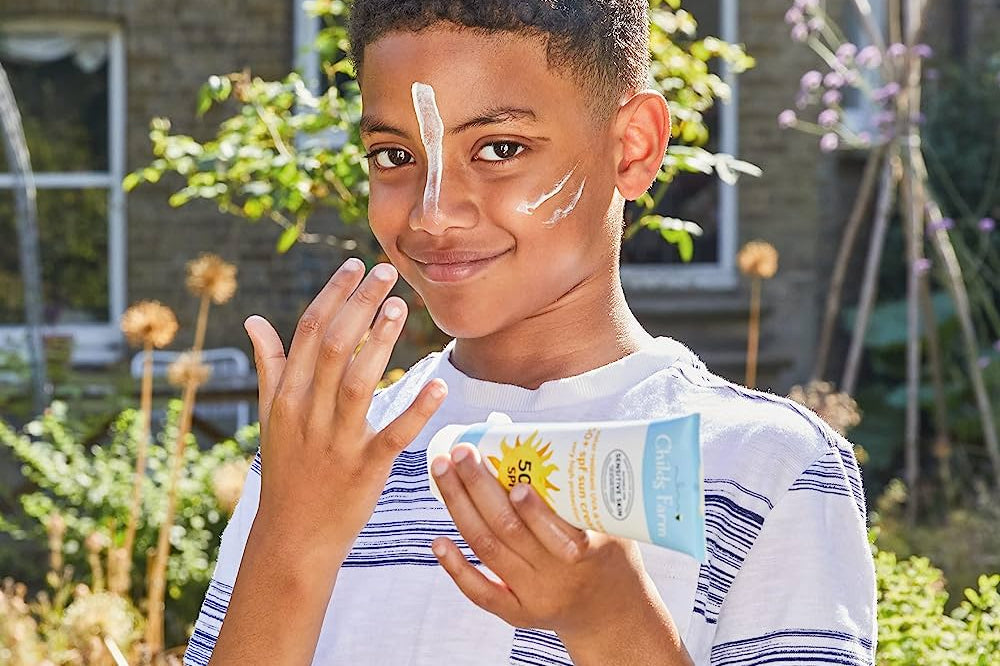 Boy with sun protection cream on his face