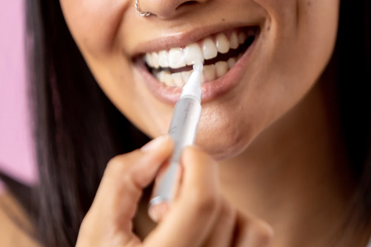 Woman using teeth whitening pen