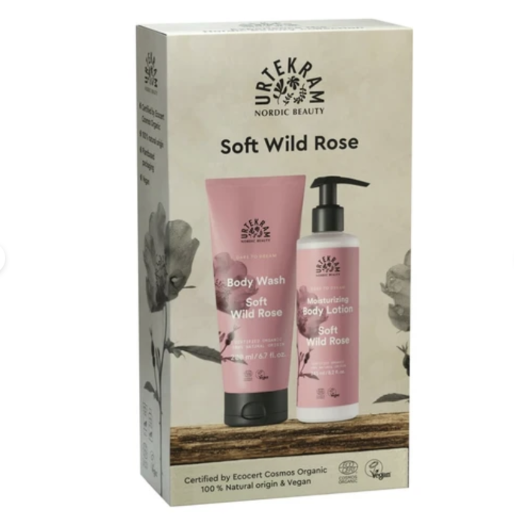 Nordic Beauty Soft Wild Rose body wash and emollient body lotion set in its original packaging box, featuring pink tubes and bottles with black pumps on a beige background.