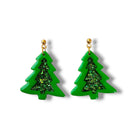 Green tree-shaped earrings with glittery centers on a white background