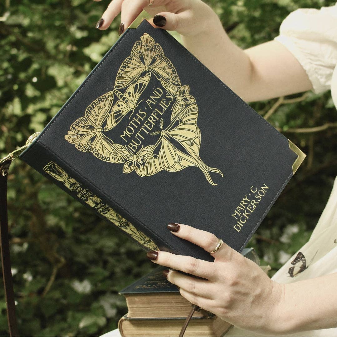 Blue book-shaped handbag with butterfly design and 'Moths and Butterflies' text 