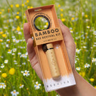 Hand holding a Bamboo Bee Revival Kit with a blurred natural background