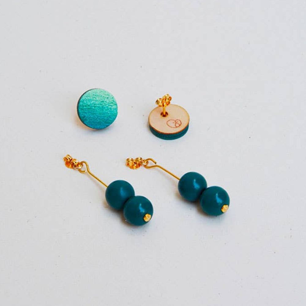 Pair of turquoise earrings with gold accents on a light gray background