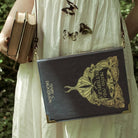 Blue book-shaped handbag with butterfly design and 'Moths and Butterflies' text 