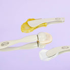 Set of three eye rollers and gels on a light purple background