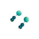 Teal earrings with gold accents on a light gray background