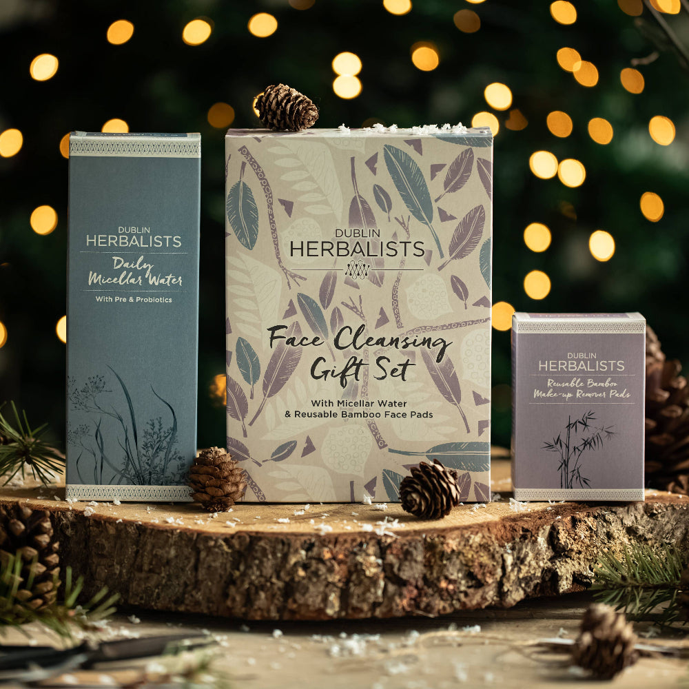 Herbalists by Nature Face Cleansing Gift Set on a wooden surface with festive lights in the background