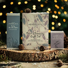 Herbalists by Nature Face Cleansing Gift Set on a wooden surface with festive lights in the background