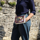 Person holding a book with a stone wall background