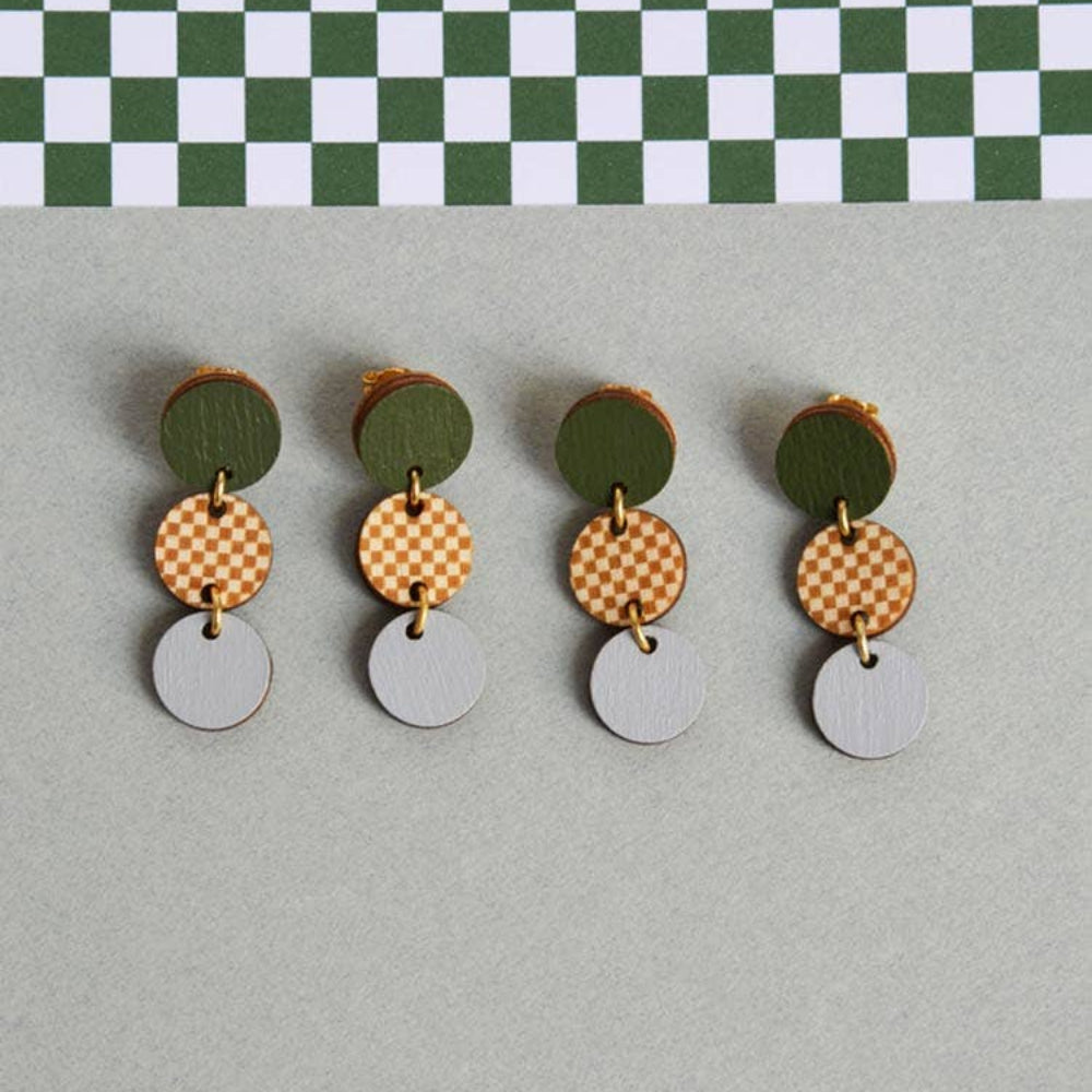 Pair of earrings with circular designs on a checkered background