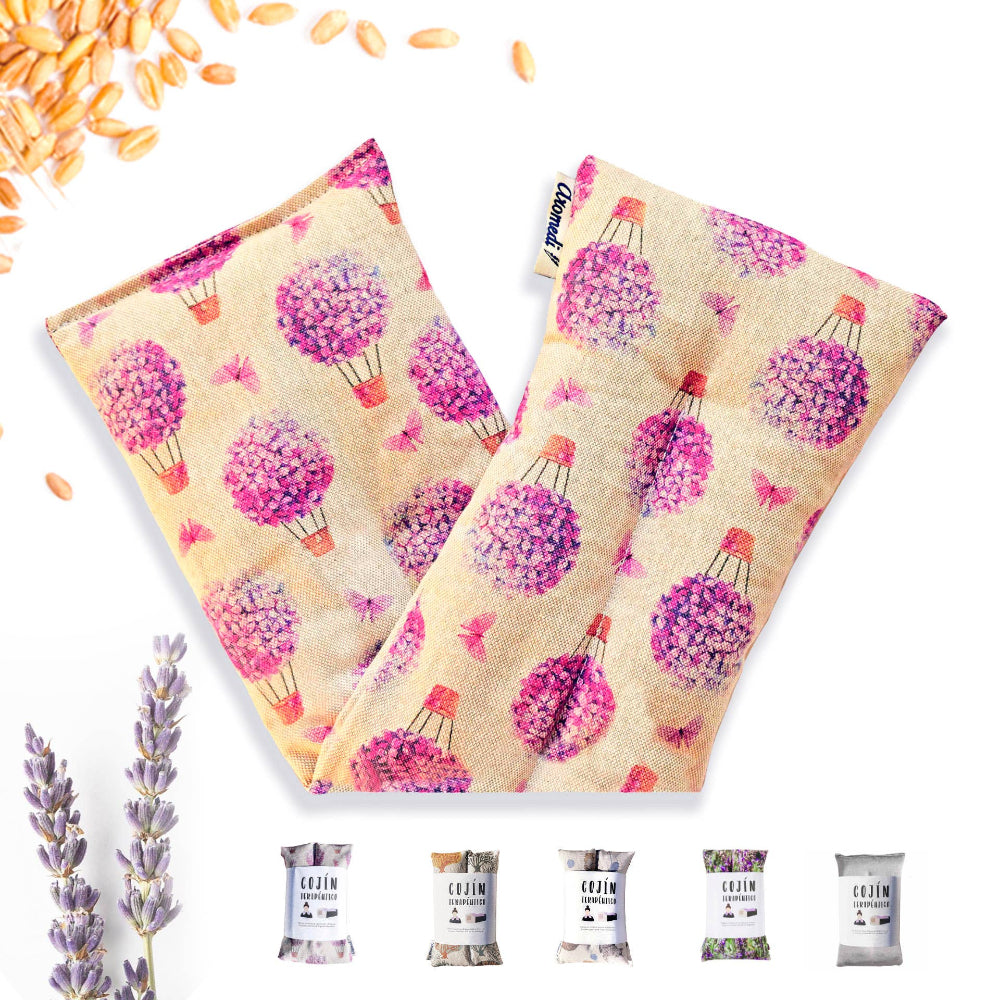 A pair of therapeutic pillows with a printed design featuring purple flowers and lavender, along with individual packaging shown in the foreground.