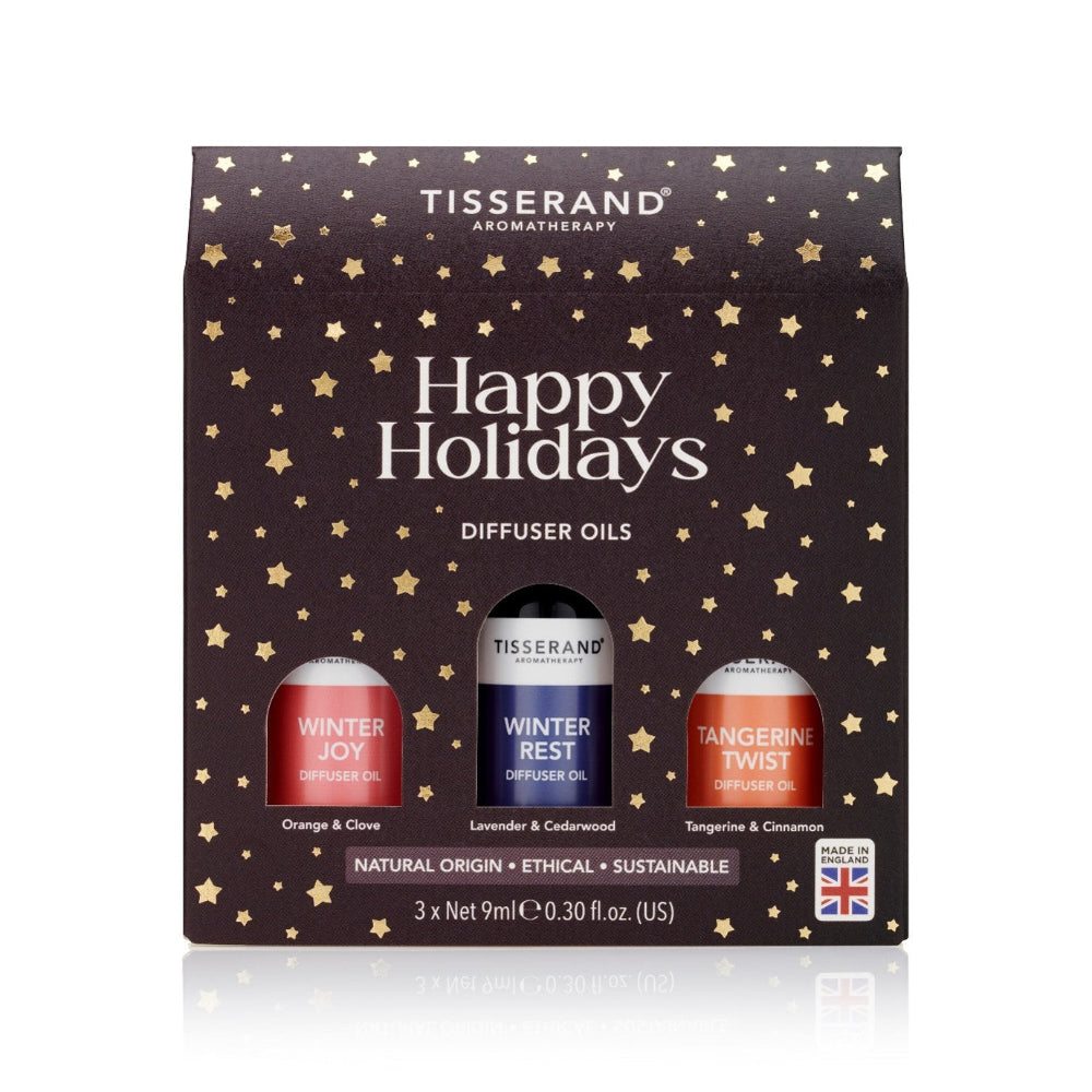 Tisserand Aromatherapy Happy Holidays diffuser oils set on a decorative box with star patterns.