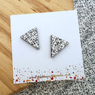 Triangle-shaped earrings on a card with a patterned background
