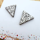 Triangle-shaped earrings with geometric pattern on a branded card