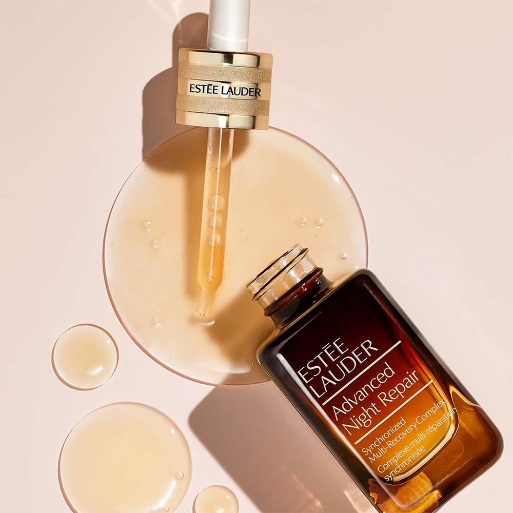 Estée Lauder Advanced Night Repair serum with dropper on a beige background