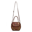 A brown woven wicker shoulder bag with a top handle, a long adjustable shoulder strap, and colorful floral embroidery on the front flap and lower body. The bag is shown against a plain white background.
