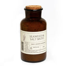 Brown bottle labeled 'Seaweed & Salt Bath' with a cork lid on a white background