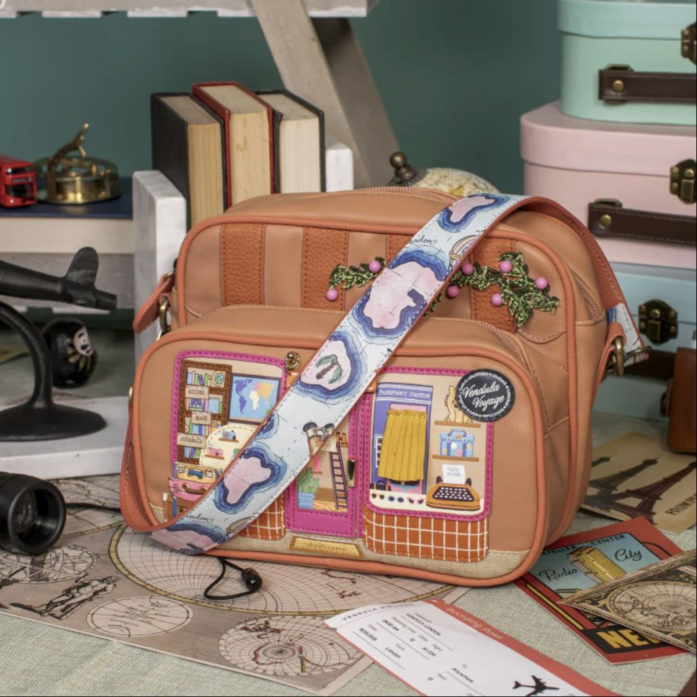 Brown patchwork bag with a colorful strap in a vintage-themed setting