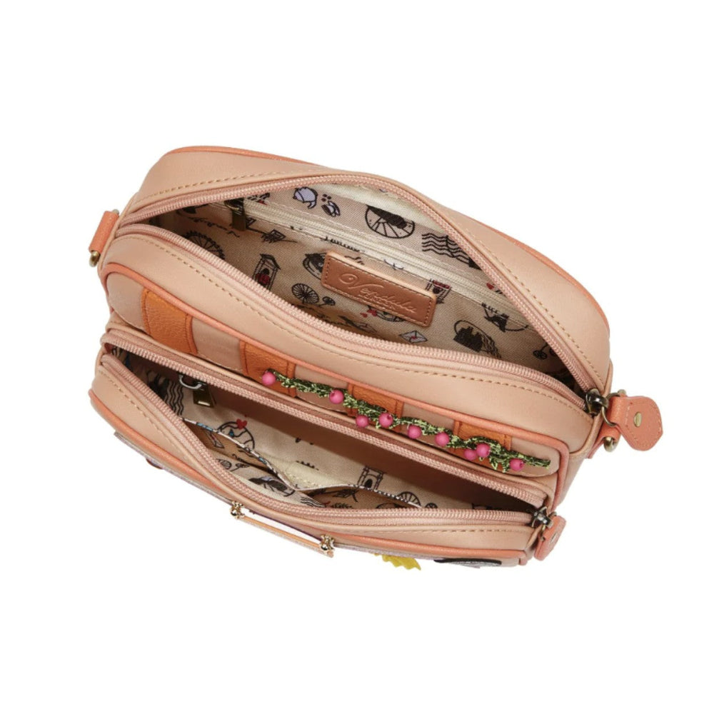 Pink crossbody bag with floral pattern on a white background
