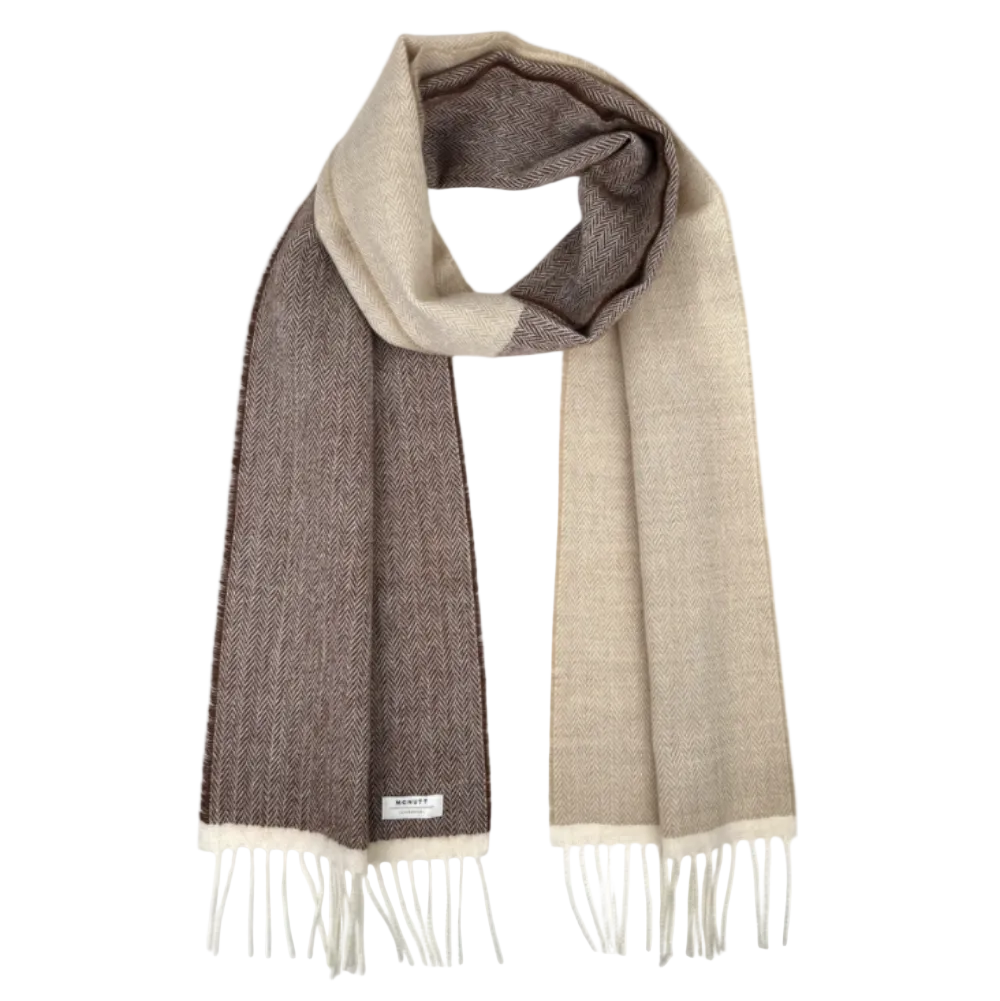 A woven scarf in a two-tone color-blocked design of taupe brown and beige, featuring white fringe ends and a small white brand label.