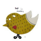 Yellow bird-shaped brooch with a red heart on a white card with 'Fiona Herbst Jewellery' branding.