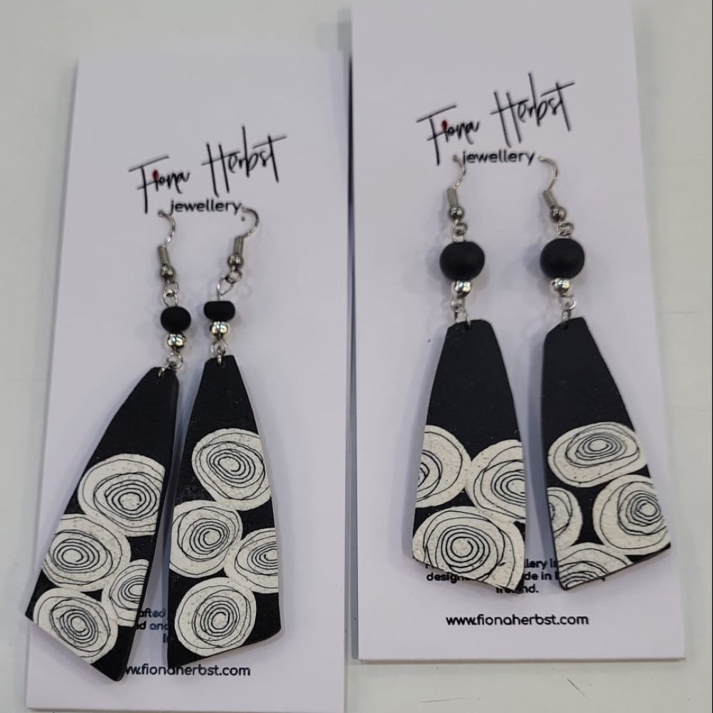 Pair of black and white patterned earrings on display cards with 'Fiona Herbst Jewellery' branding.
