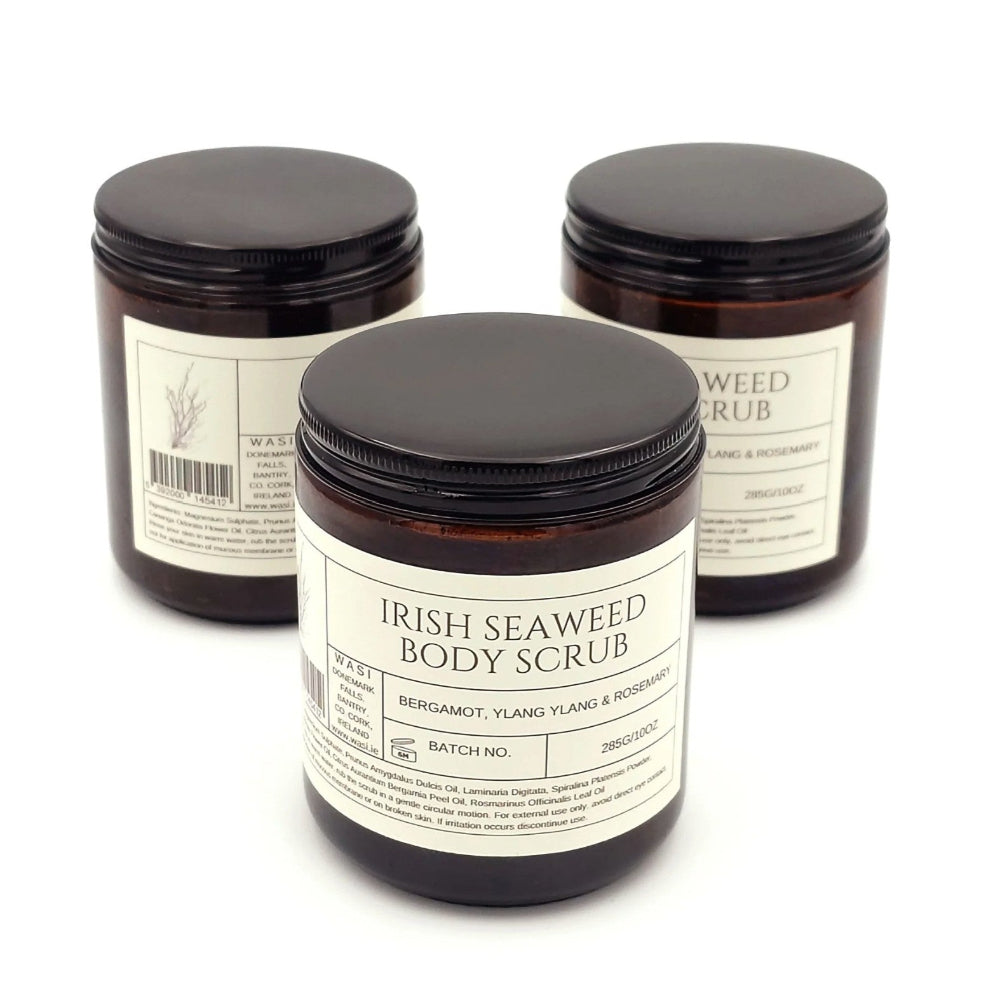Three jars of Irish Seaweed Body Scrub with black lids on a white background