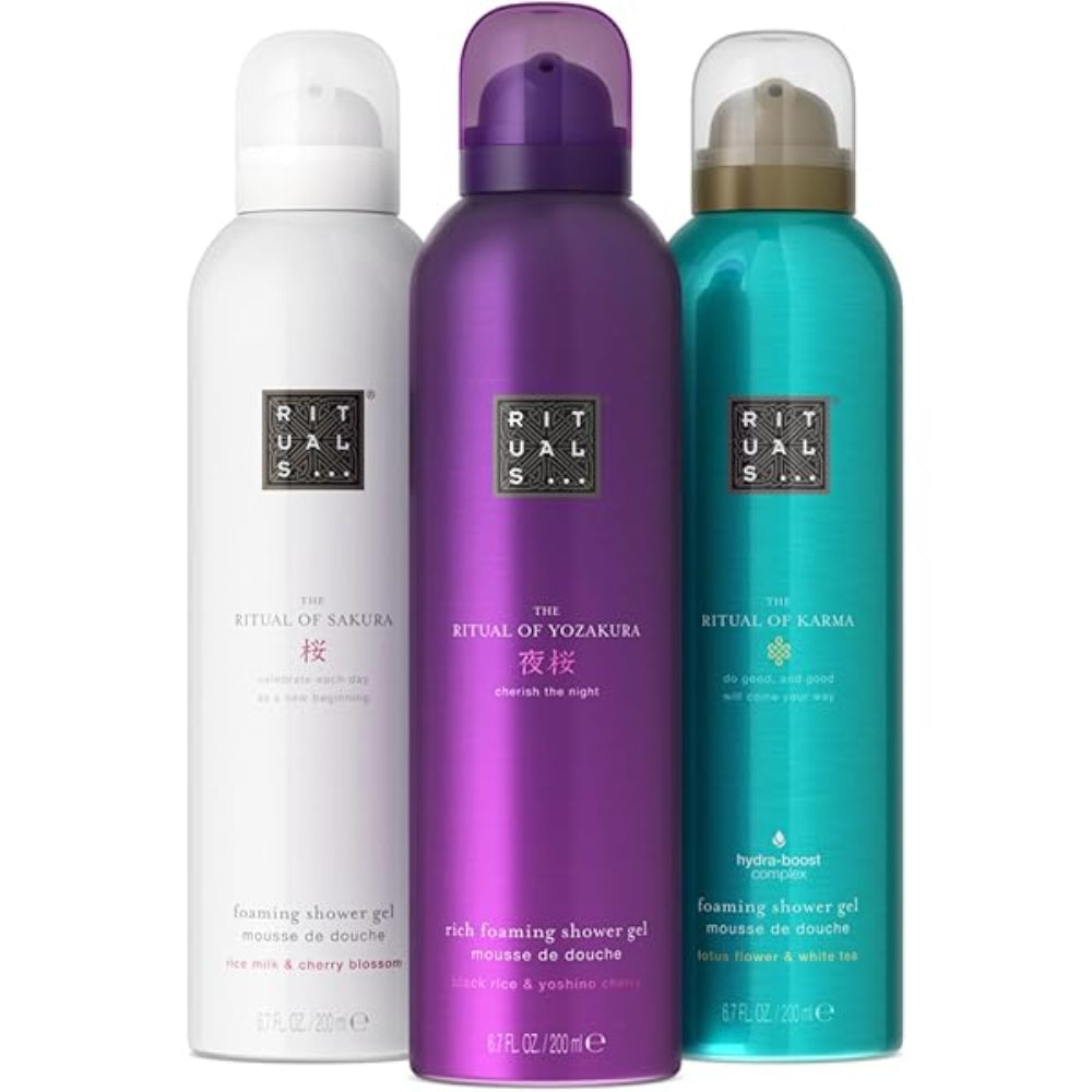 Three bottles of Rituals shower gel in white, purple, and teal on a white background