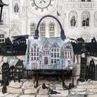 A structured handbag with a printed illustration of London buildings, displayed on a miniature black stand in front of a London-themed backdrop featuring paper cutouts of Big Ben and a clock tower.