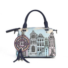 A structured handbag with a light blue and pink cityscape illustration, navy blue handles and tassels, and a large circular decorative charm, shown on a white background.