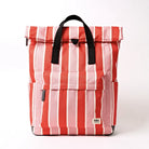 A roll-top backpack with vertical red, pink, and white stripes, featuring black webbed top handles