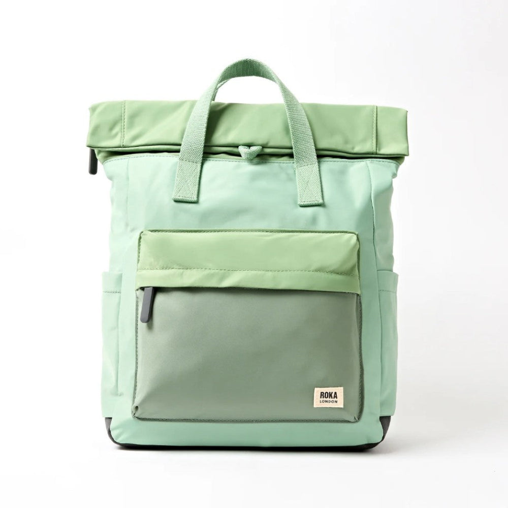 A mint green roll-top backpack with a front zippered pocket.