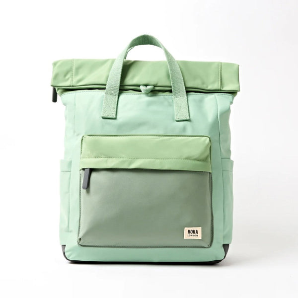 A mint green roll-top backpack with a front zippered pocket.