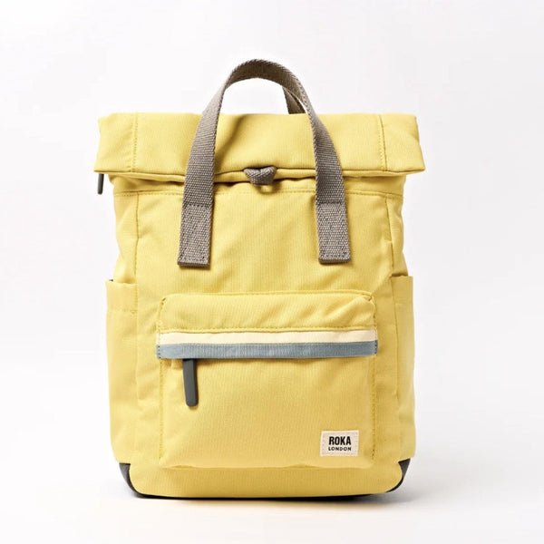 A yellow ROKA London roll-top backpack with grey handles and a grey reflective stripe on the front zip pocket.