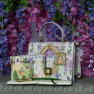 Decorative handbag with fairy tale design against a floral background