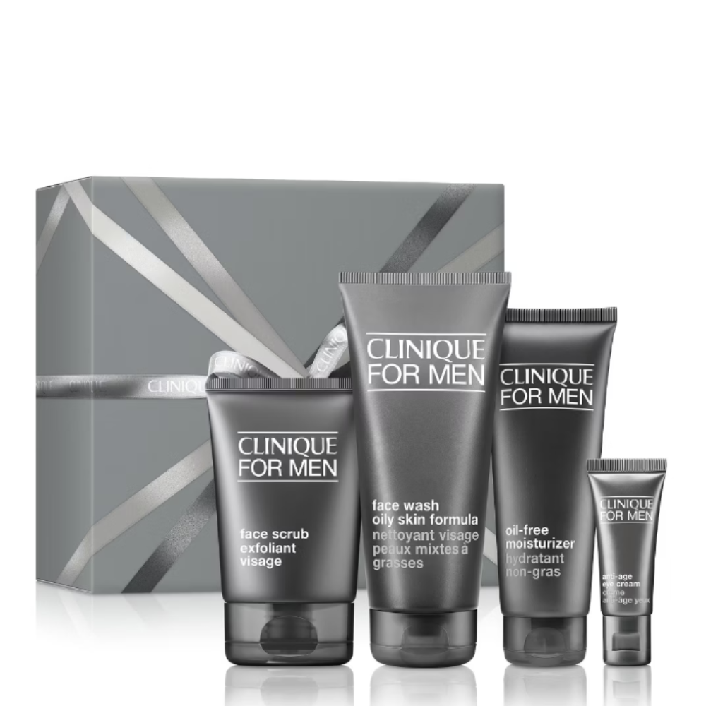 Clinique For Men skincare gift set featuring a face wash, face scrub, oil skin formula, and body lotion in dark gray tubes, displayed in front of a matching gray gift box on a white background.