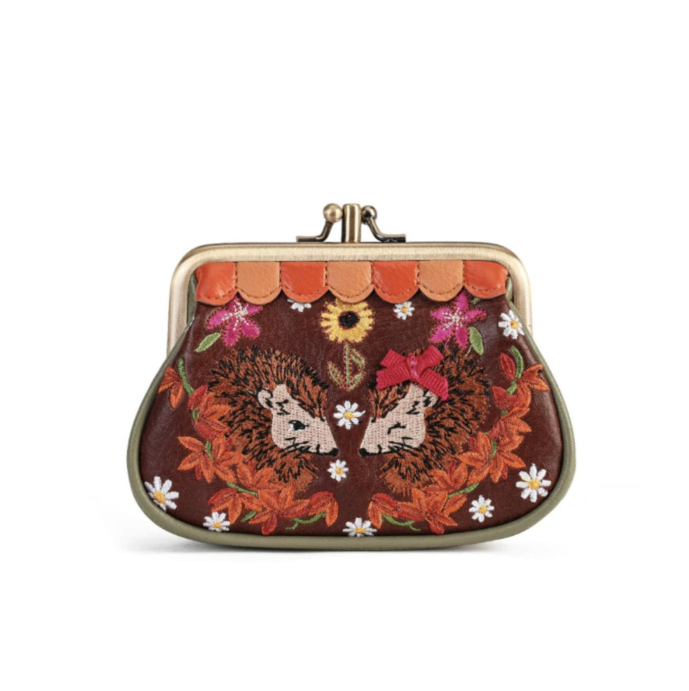 A small kiss-lock coin purse with a brown background and an embroidered hedgehog and autumn floral design in orange, red, pink, white, and green.