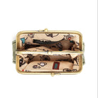 An open kiss-lock coin purse shown from a top-down view, featuring a gold-tone metal frame and a beige printed fabric lining with black illustrations of teapots, cups, and a red telephone booth.