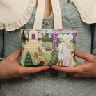 Person holding a small purse with fairy tale design