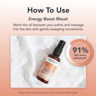 Tisserand Energy Boost massage oil bottle with usage instructions on a soft pink background