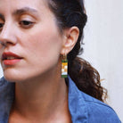 Close-up of a woman wearing a colorful earring with a blurred background