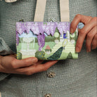 Person holding a small wallet with garden design