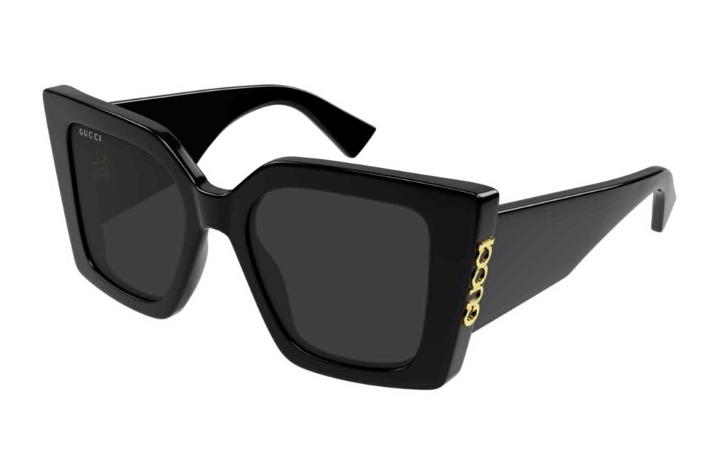 Black sunglasses with gold Gucci detail on a white background